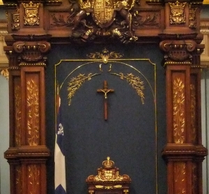 Trois symboles chrétiens qui entourent encore la chaise du président de l&#039;Assemblée nationale du Québec: le crucifix, la croix blanche du drapeau du Québec et la devise &quot;Dieu et mon droit&quot;, empruntée à la Couronne anglaise. 